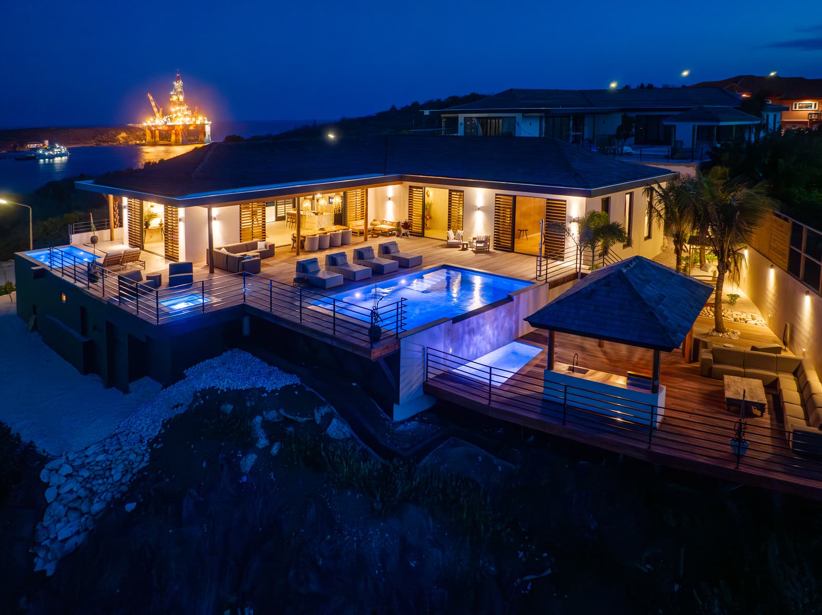 Villa C-Bay View bij avond, verlichte zwembaden aan de Caracasbaai
